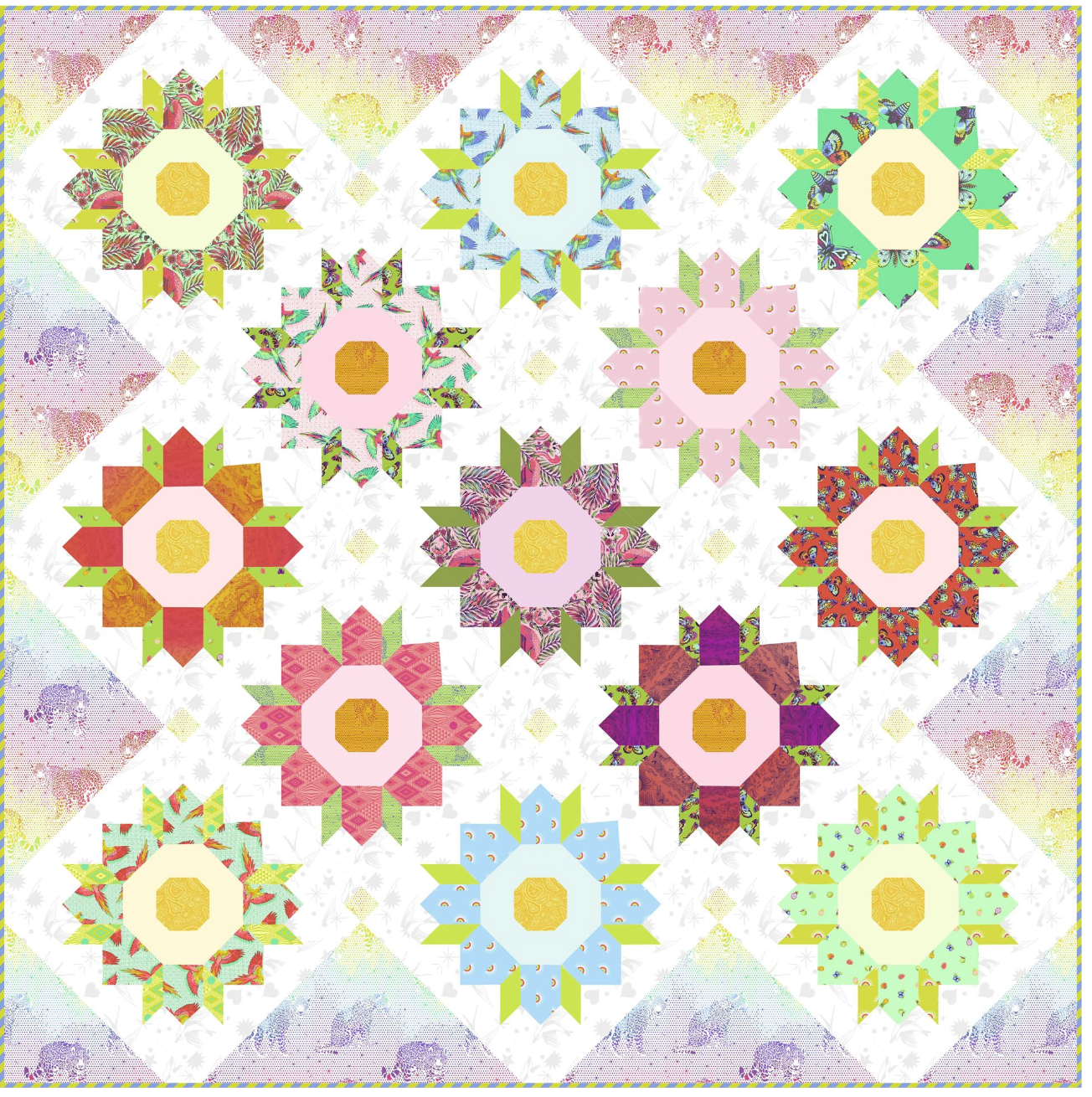 A quilted fabric panel featuring a repeating pattern of colorful starburst flower blocks arranged in a diamond grid, with a soft pastel elephant-print border.