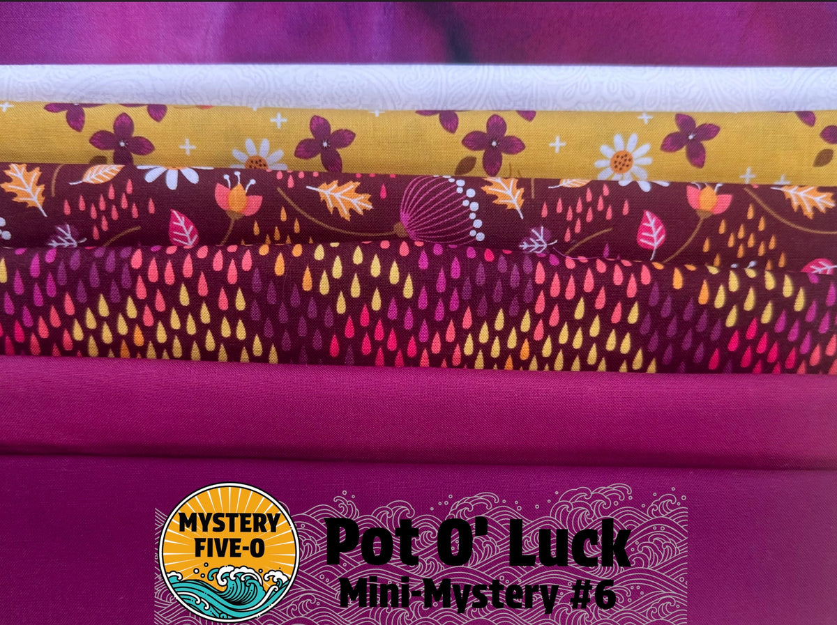 A stack of folded patterned fabric samples in bright magenta, yellow, and dark red floral/raindrop prints, with a logo and text reading 'Mystery Five-O Pot O' Luck Mini-Mystery #6' at the bottom.