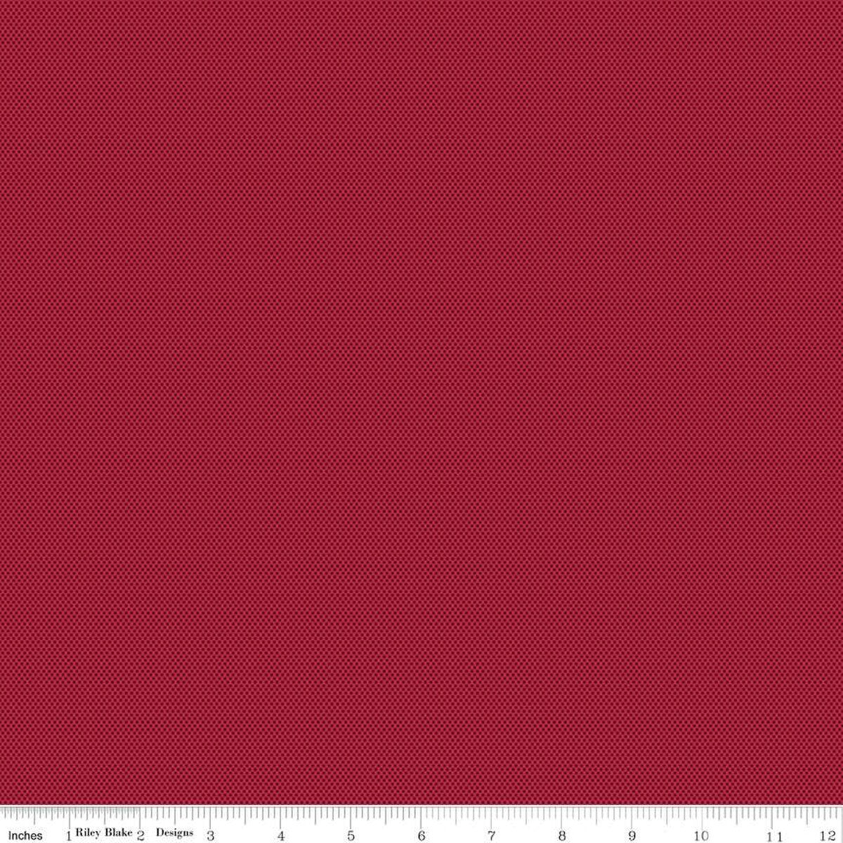 A close-up of a red fabric texture with a pattern of tiny dark red dots