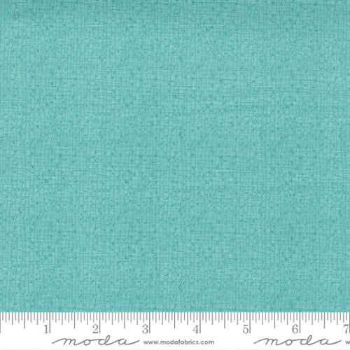 A close-up of a turquoise fabric swatch with a fine woven texture.