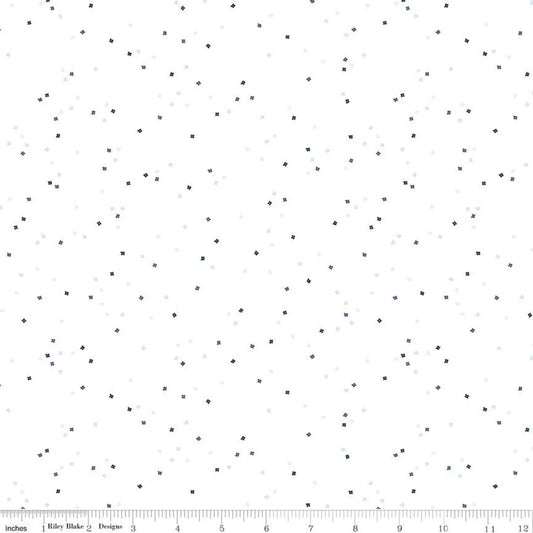 White fabric with a scattered pattern of tiny dark navy and light blue  colored confetti blossoms 