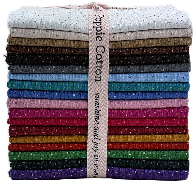 A rainbow colored stack of folded cotton fabrics in multiple colors, each with small polka dots, tied together with a beige ribbon that reads Poppy Cotton 