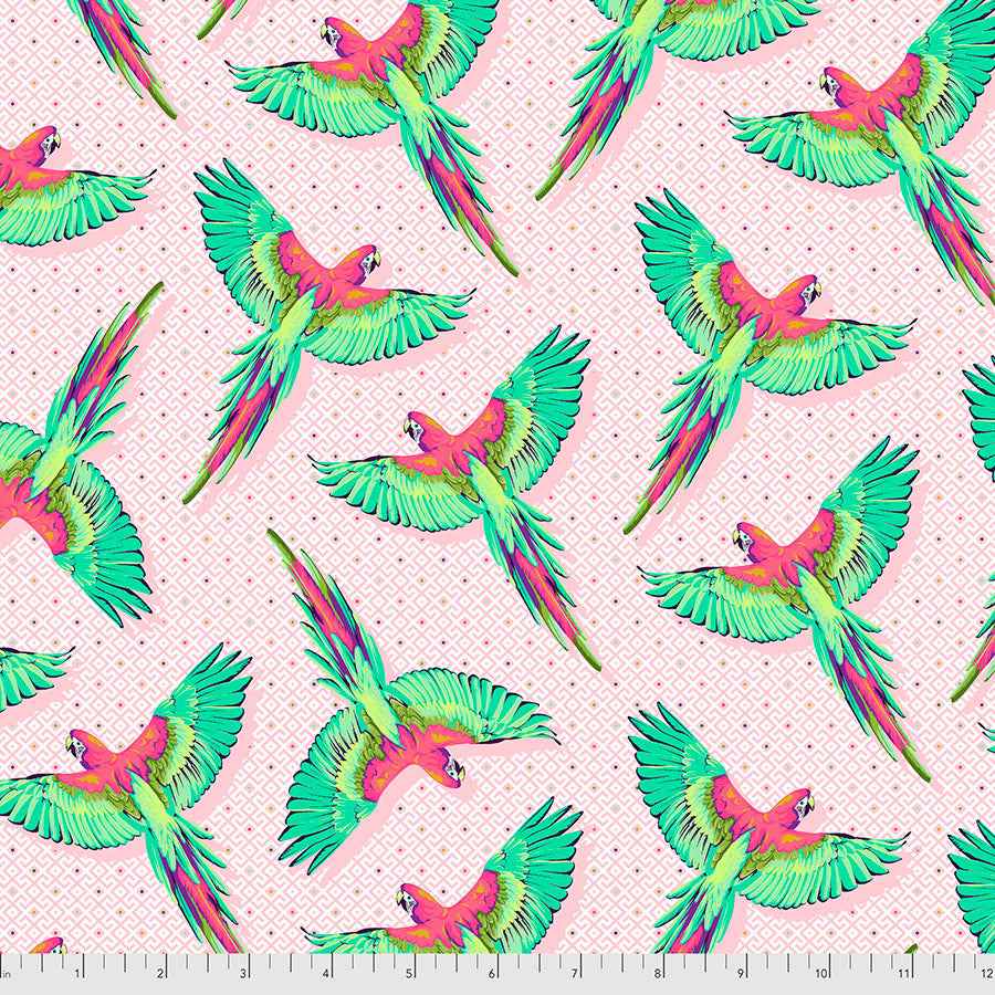 A fabric with a pattern of colorful macaw parrots flying against a pink background.