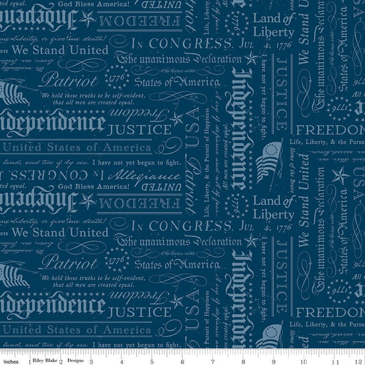 A close-up of a repeating fabric pattern featuring vintage American-themed typography with words like 'Independence,' 'Liberty,' 'Justice,' 'Patriot,' and 'We Stand United' in muted light blue tones on a blue background.