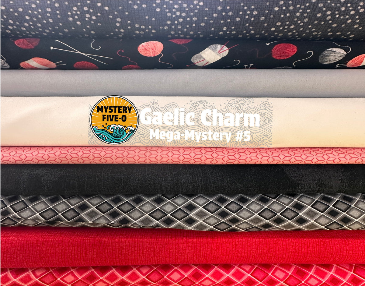 A stack of folded fabric samples that  include dark grey with white dots and yarn motifs, light gray, cream, pink, black, silver-gray, bright red, and textured red fabrics.