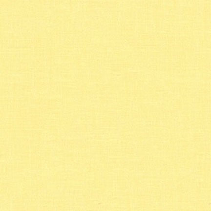 A close-up of a pale pastel yellow textured material, likely fabric 